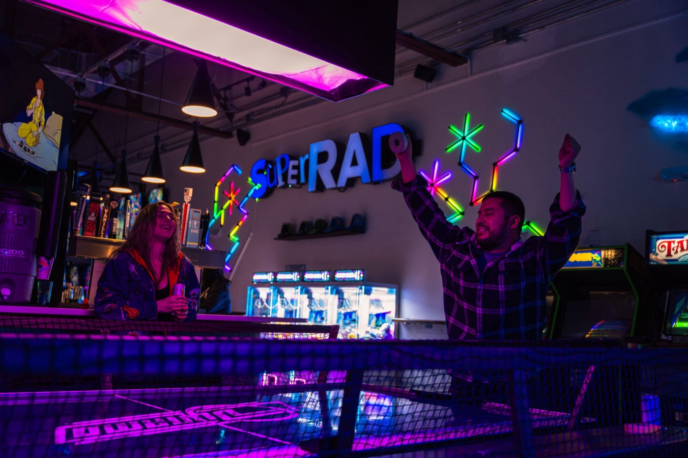 Crowd under the Super Rad neon sign